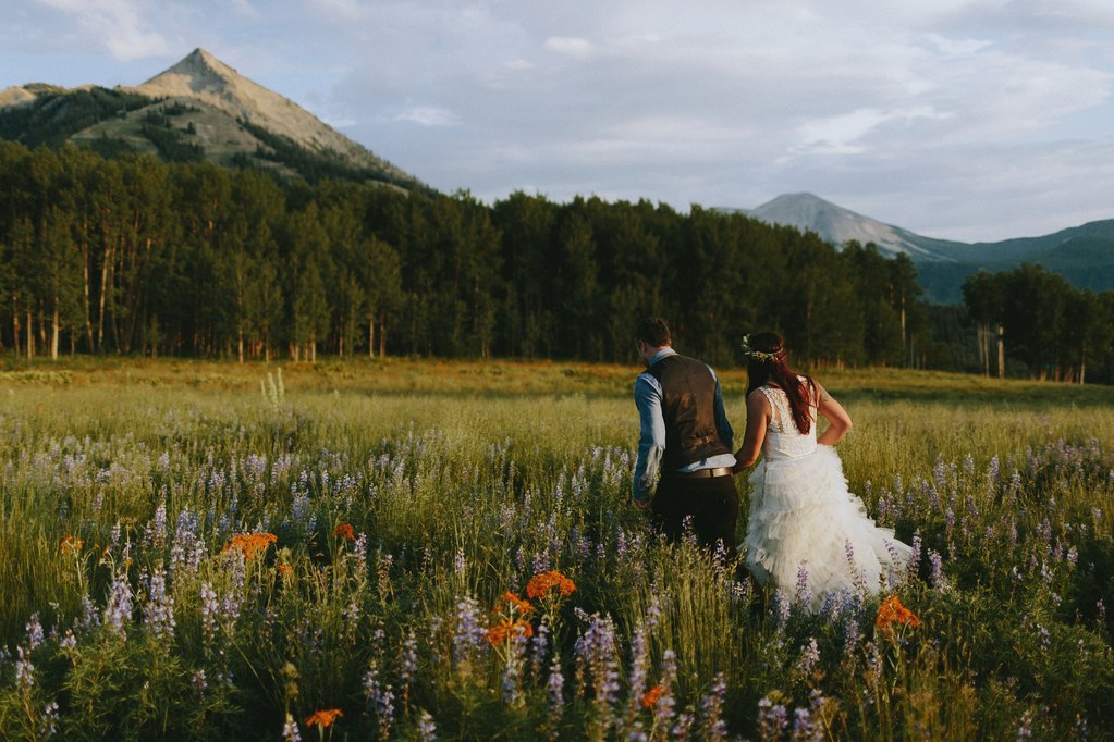 Bride and Groom walking through wildflowers
