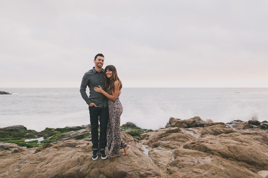 Engaged couple on beach cliff near Santa Cruz